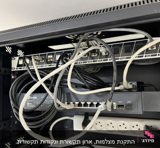 מתג רשת TP-Link עם כבלים מחוברים ויציאות חשמל